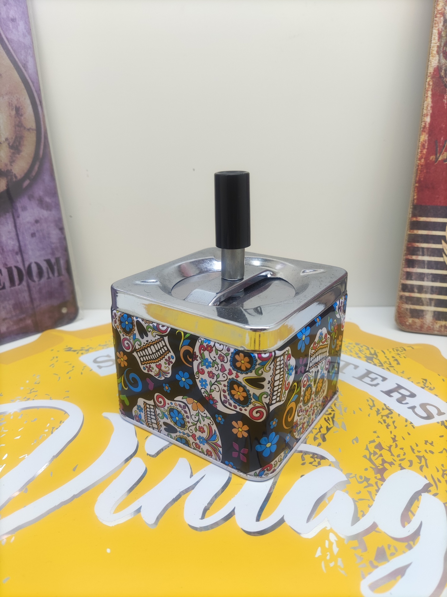 Cinzeiro metálico quadrado decorado com caveiras e flores coloridas