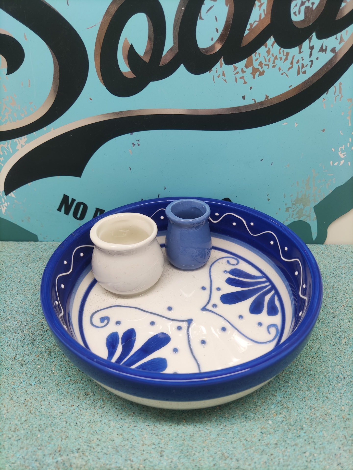 Taça de cerâmica azul e branca com dois pequenos recipientes no interior