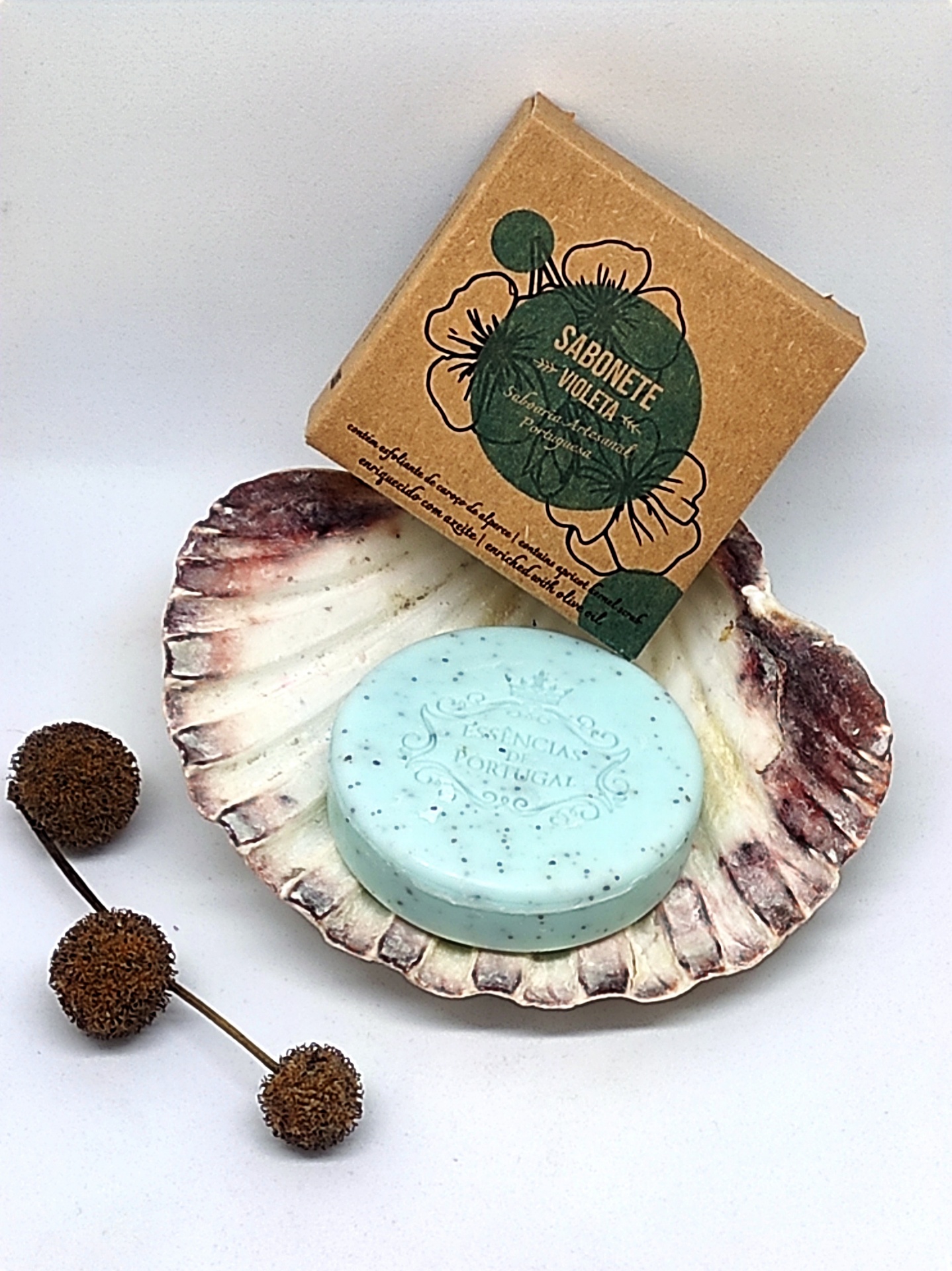 Sabonete azul claro em concha com embalagem de papel castanho e texto SABONETE VIOLETA