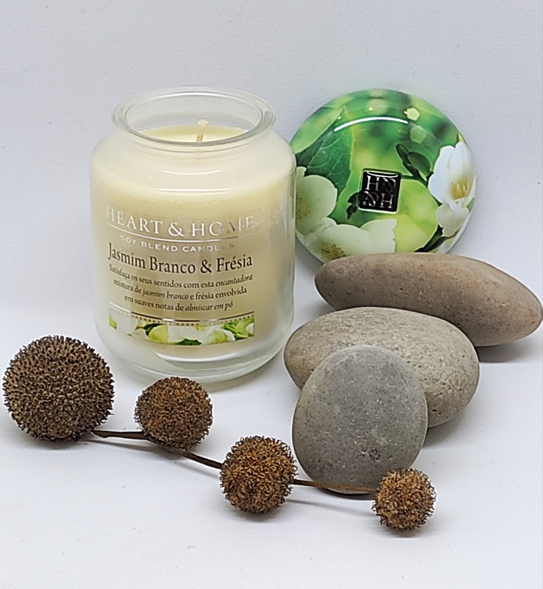 Vela em jarra de vidro com tampa floral, pedras e frutos secos decorativos