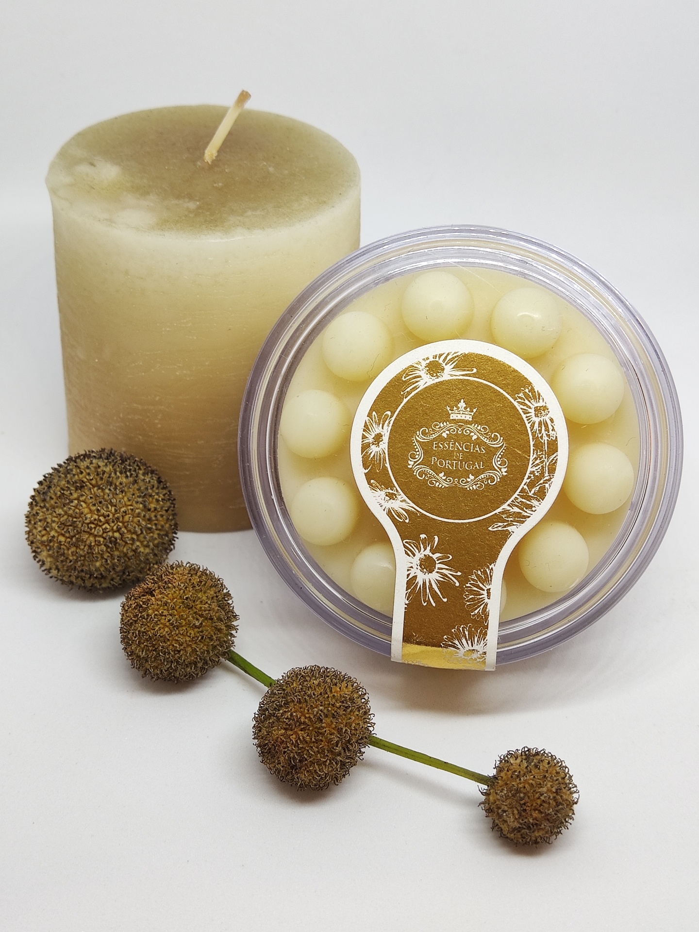 Vela cylindrical, pacote de esferas brancas e frutos secos castanhos sobre fundo branco