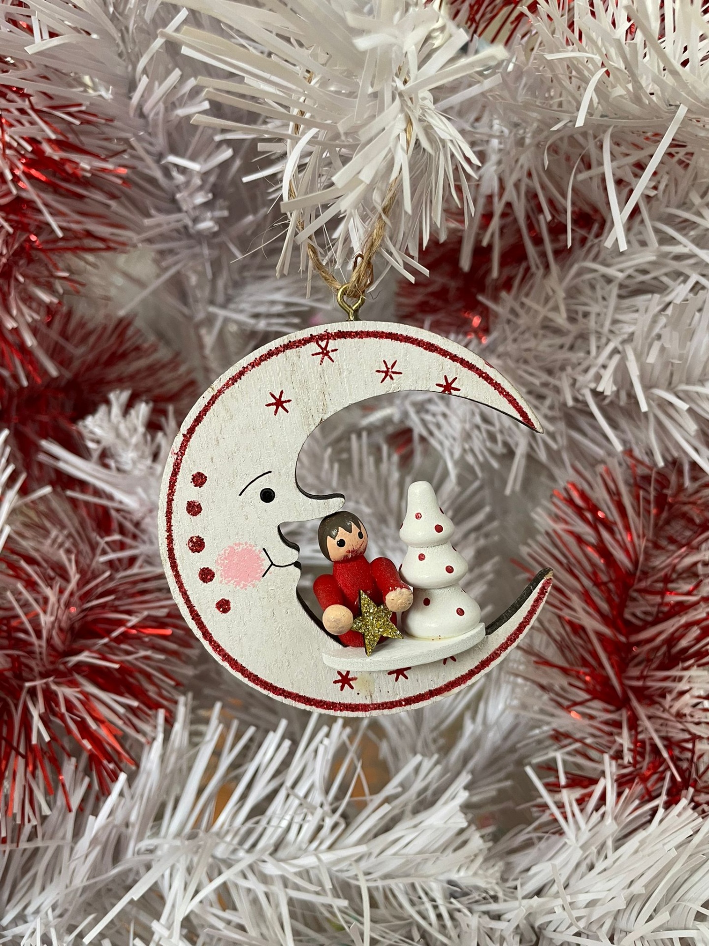 Enfeite de Natal lua crescente com criança e árvore de Natal pendurado em árvore branca e vermelha