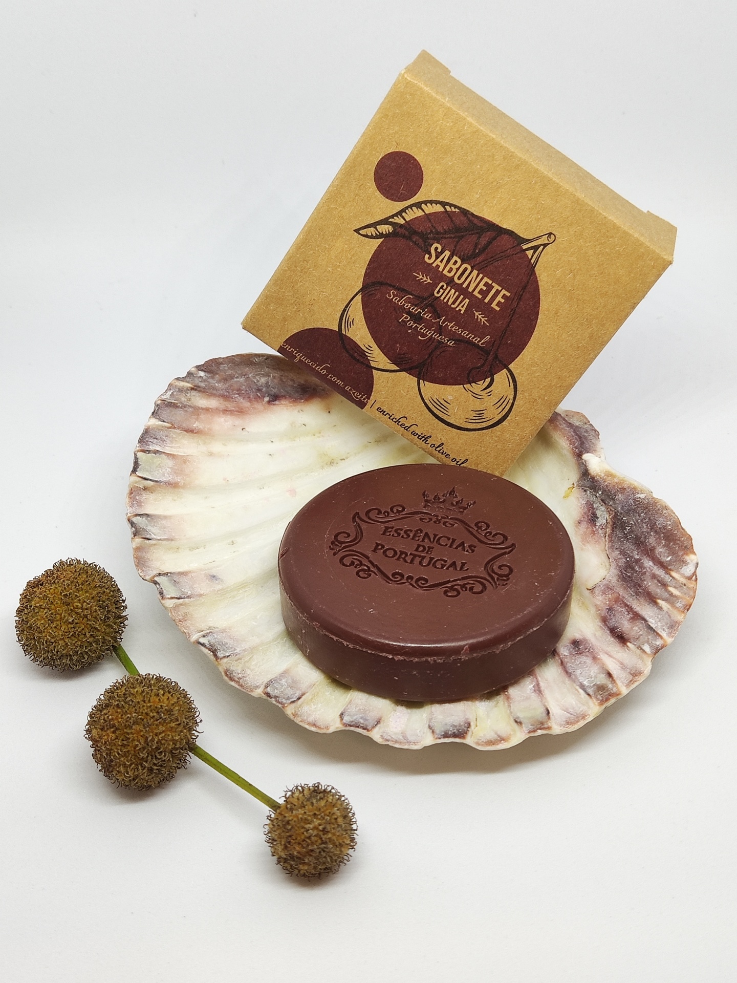 Sabonete castanho redondo em concha com embalagem de cartão e flores secas