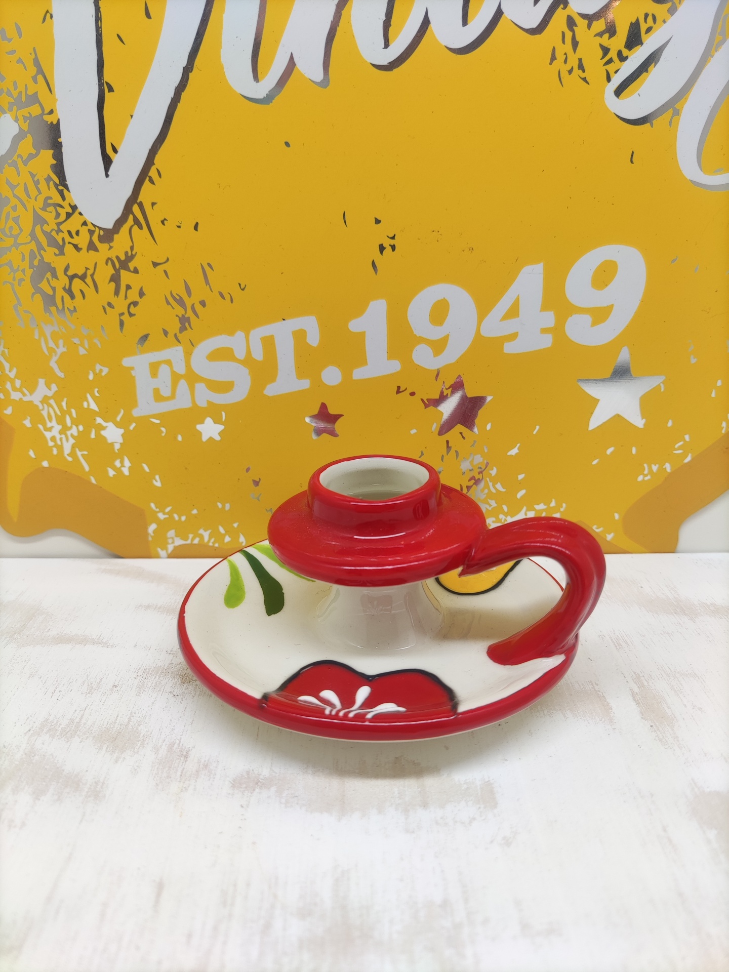 Candelabro de cerâmica decorativa com padrão floral colorido na base e pega