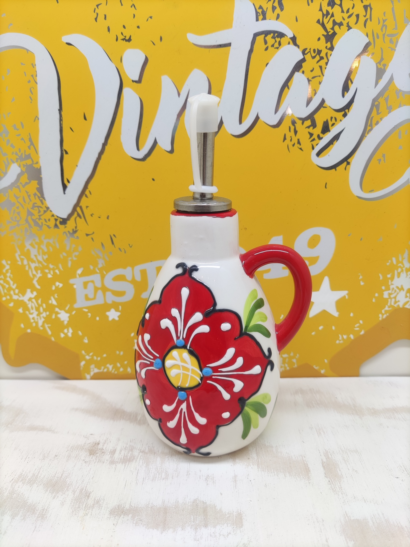 Frasco doseador de cerâmica decorado com flor vermelha e tampa metálica