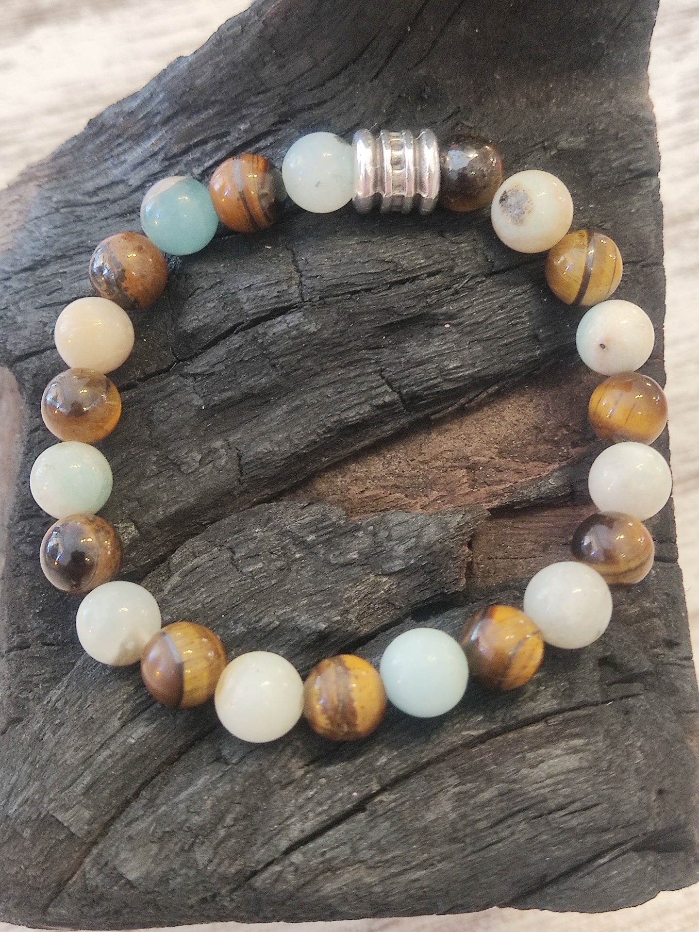 Pulseira com contas redondas azuis, bege e castanho com detalhe metálico prateado