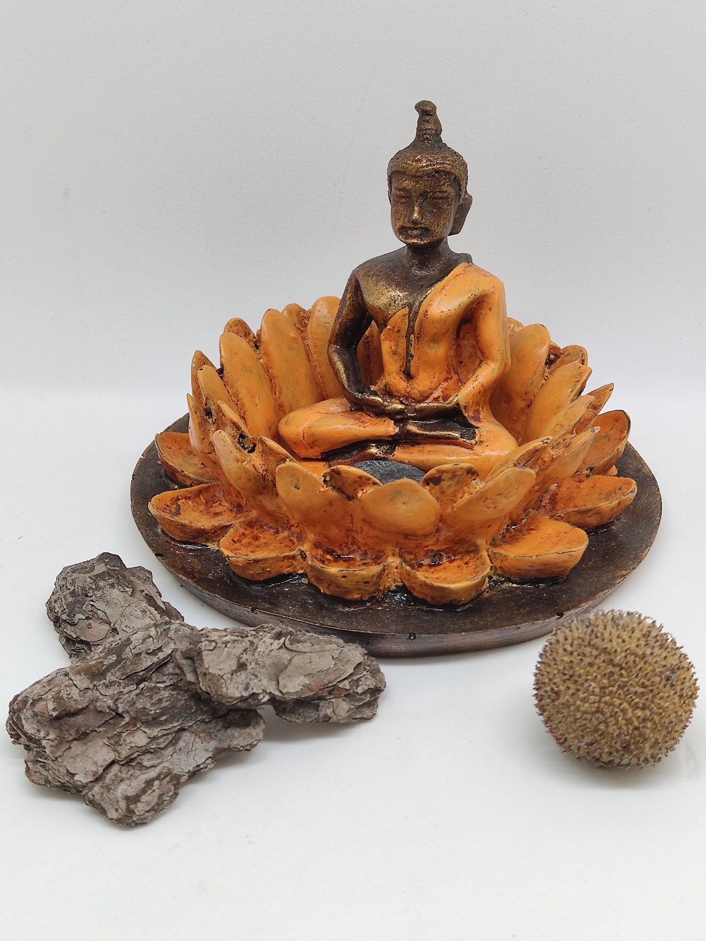 Estátua de Buda em cerâmica laranja e castanha com base redonda e objetos decorativos