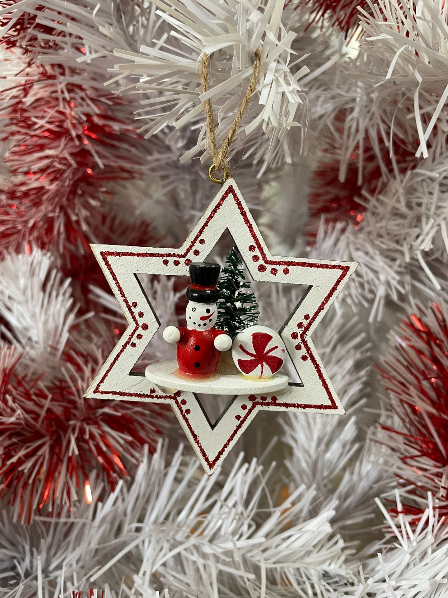 Decoração natalícia em forma de estrela com boneco de neve e árvore de Natal