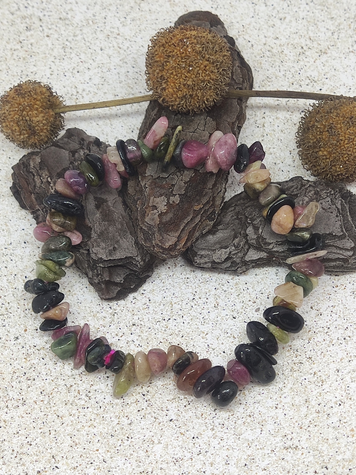 Pulseira de pedras naturais multicoloridas sobre cascas de madeira