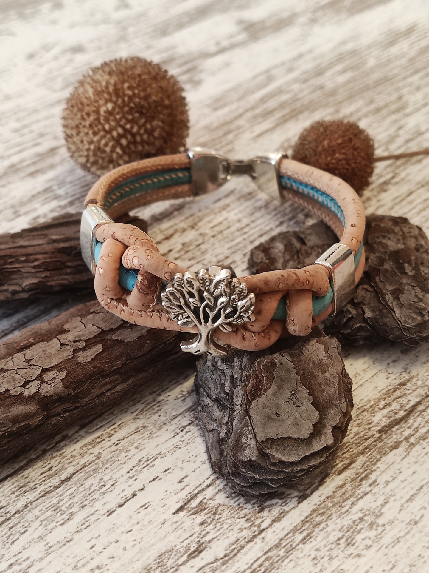 Pulseira de cortiça com pingente de árvore prateado sobre madeira rústica
