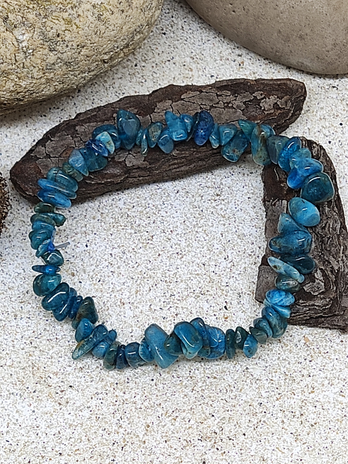 Pulseira de pedras azuis sobre casca e areia