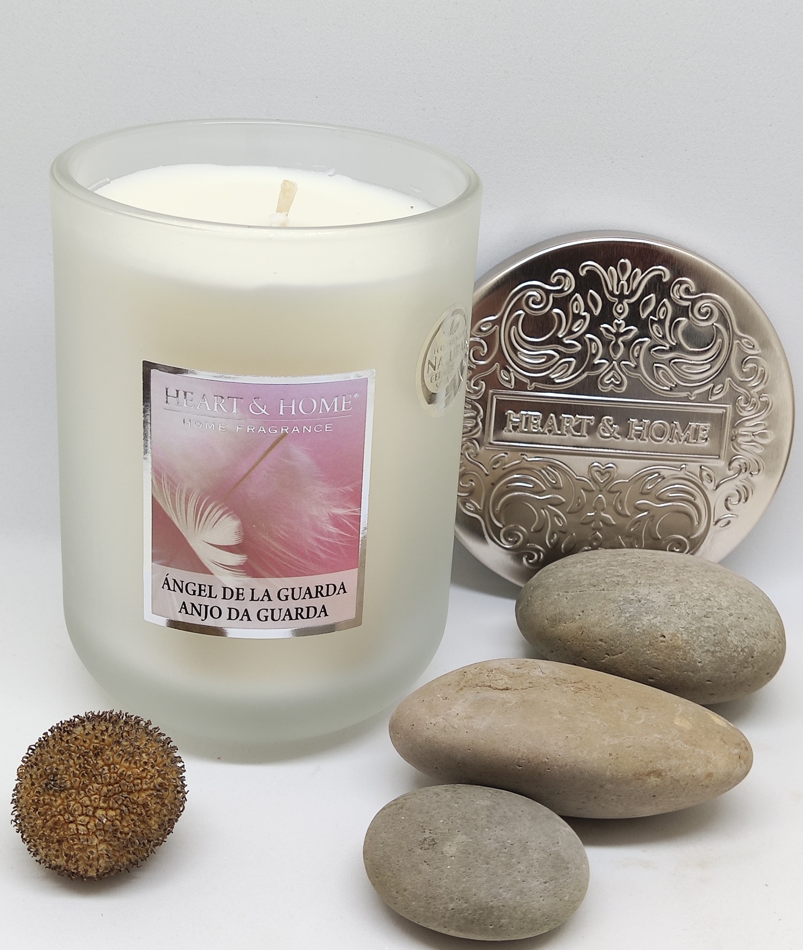 Vela perfumada HEART & HOME em vidro fosco branco com tampa metálica decorativa e pedras ao lado