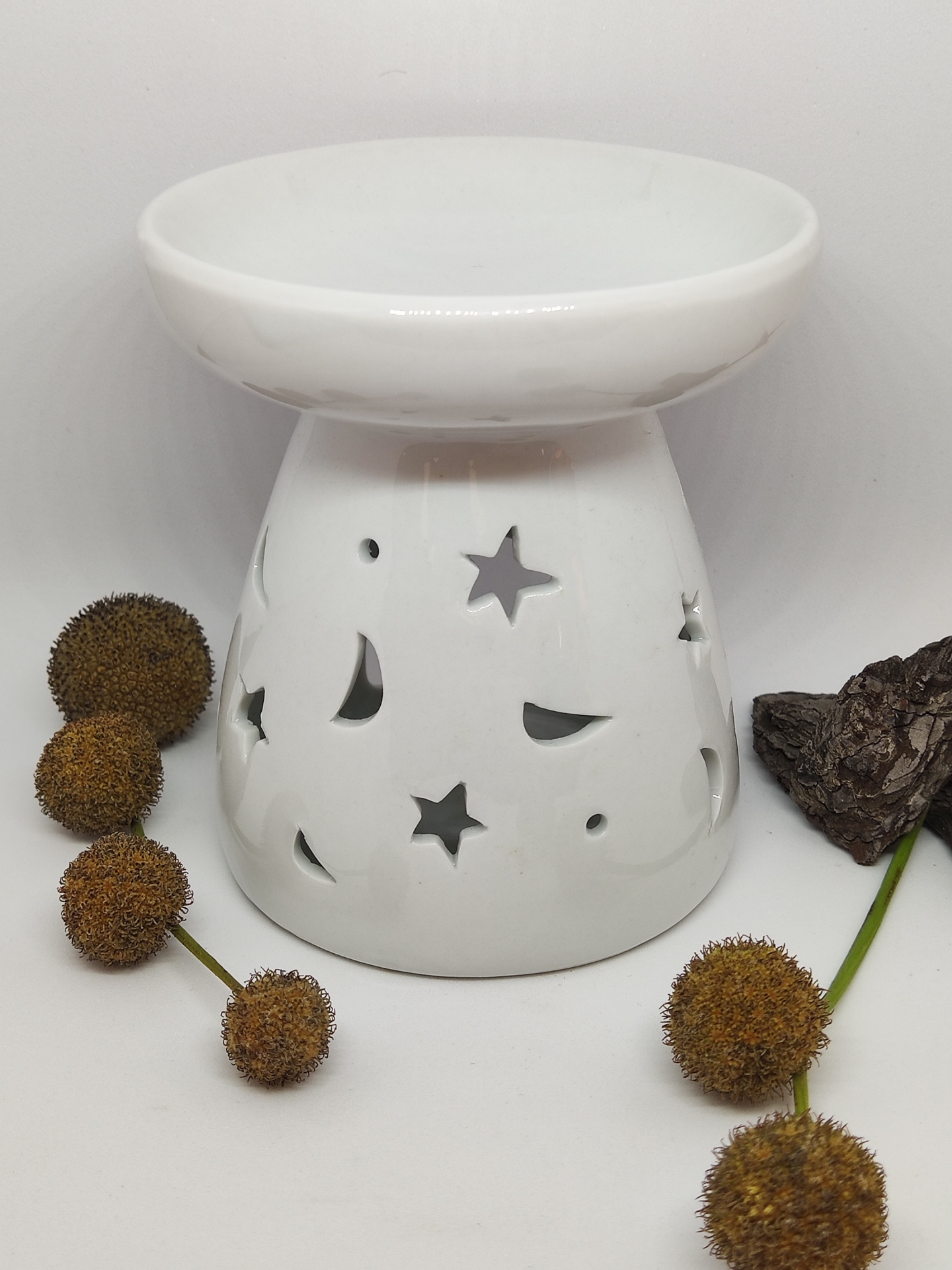 Lâmpada aromatizante cerâmica branca com recortes de estrelas e luas com flores secas