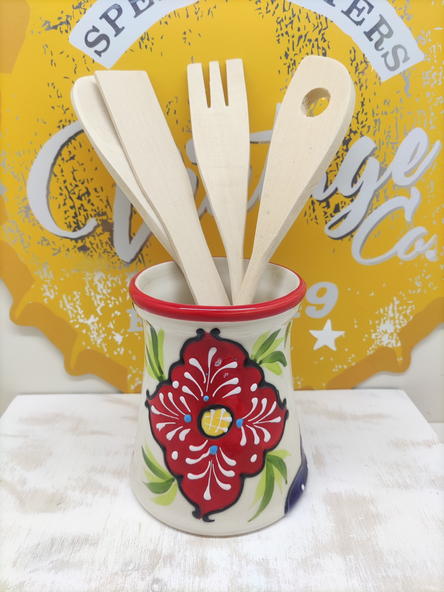 Utensílios de cozinha em madeira dentro de suporte de cerâmica decorado com padrão floral