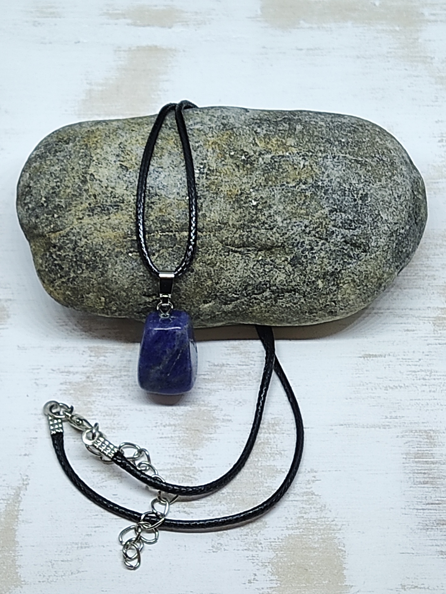 Colar com pendente de pedra azul sobre pedra cinzenta