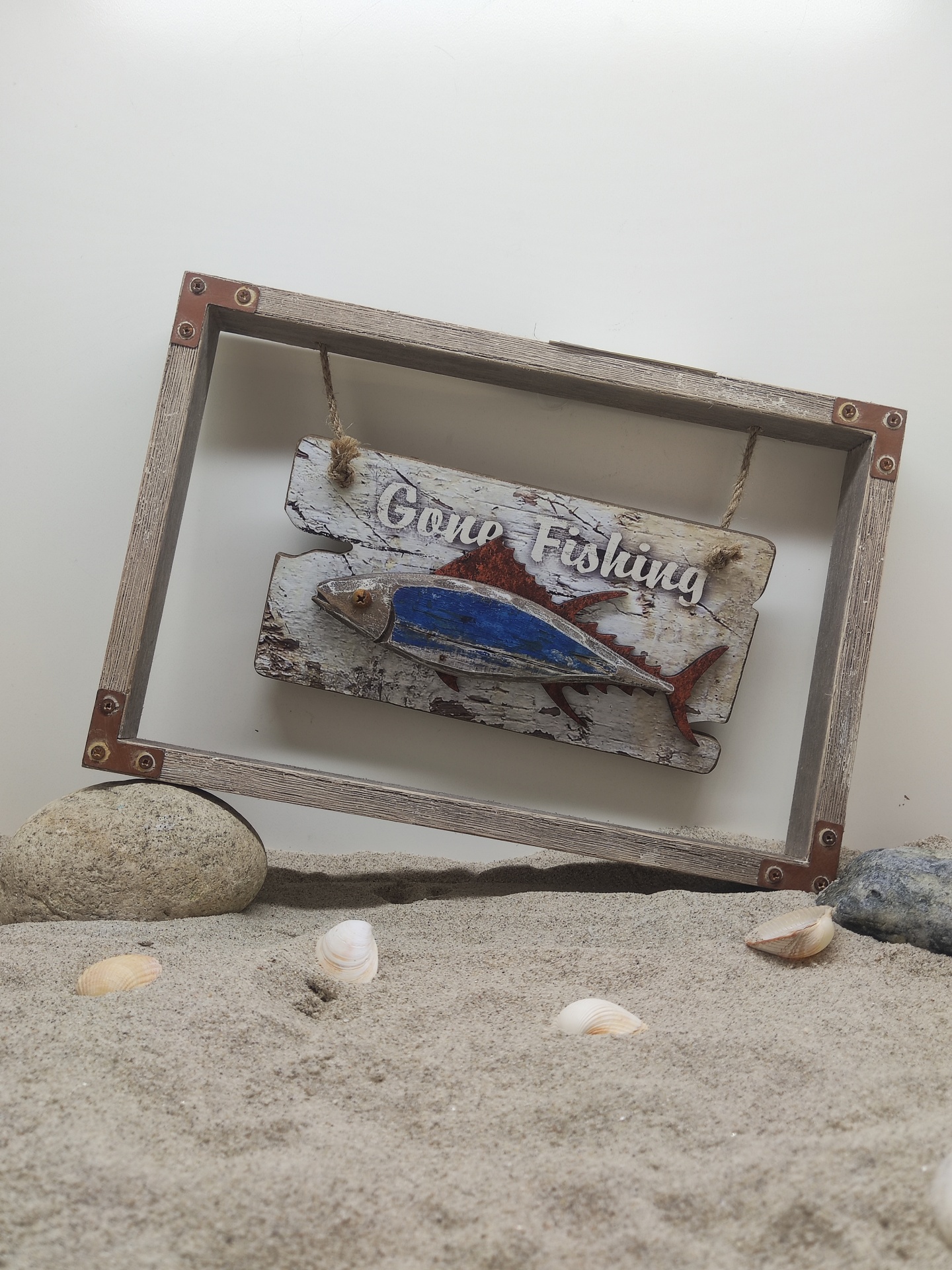 Placa decorativa de madeira com moldura rústica e peixe pendurado