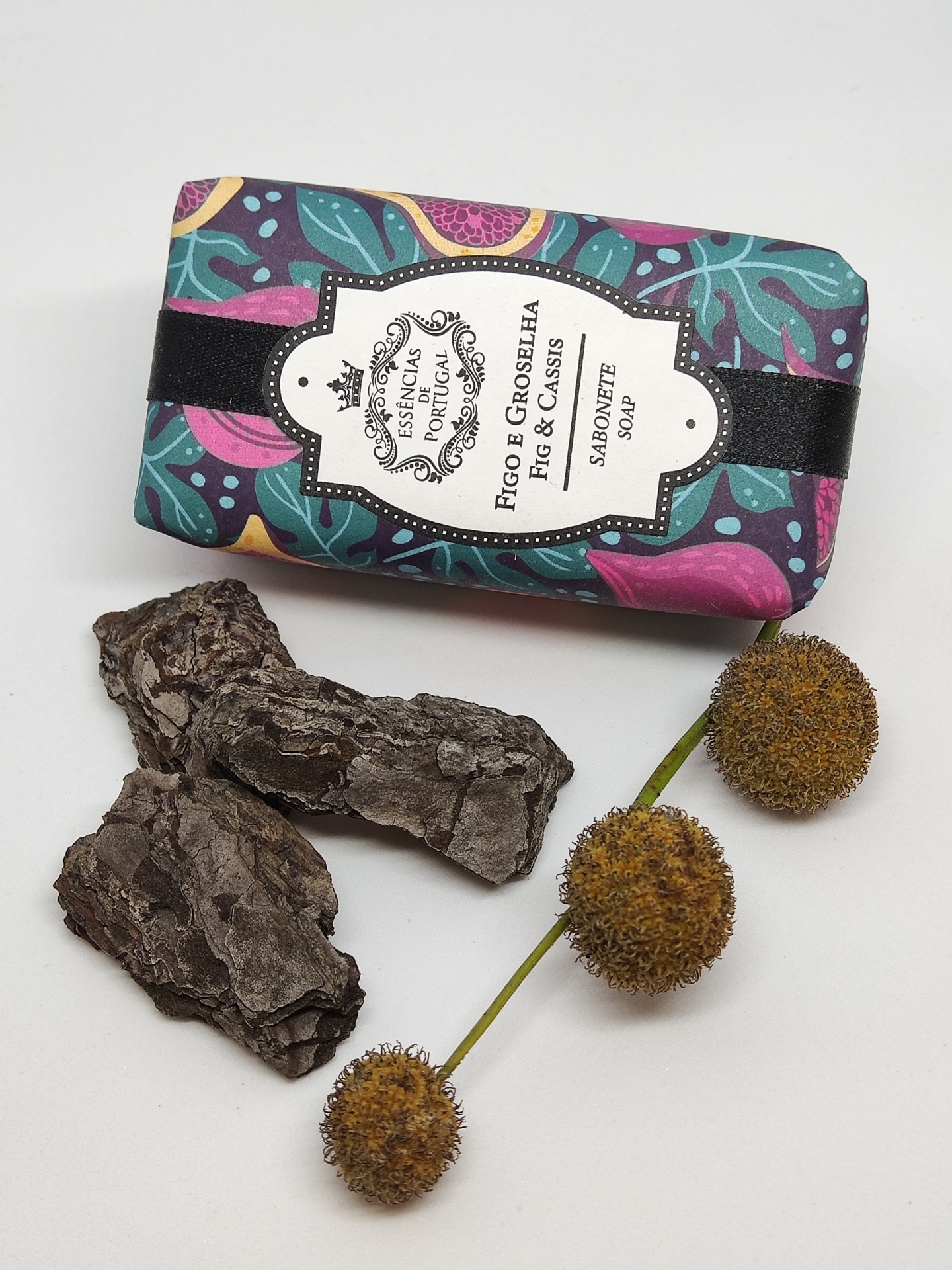 Sabonete embalado com padrão floral acompanhado por pedaços de casca e bolbos espinhosos