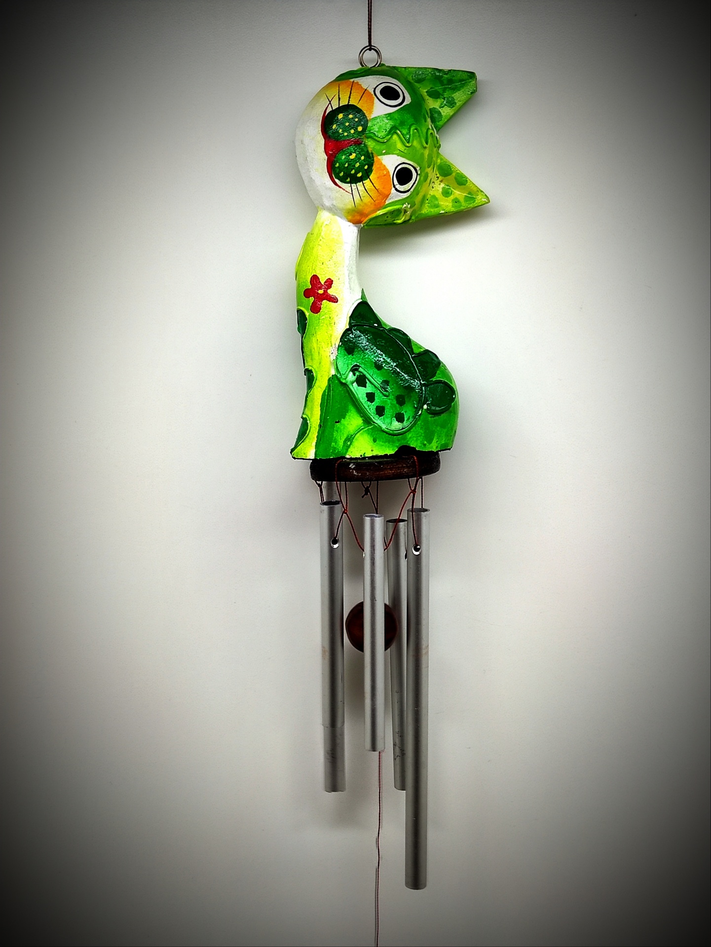 Sino dos ventos decorativo em forma de gato verde e branco.