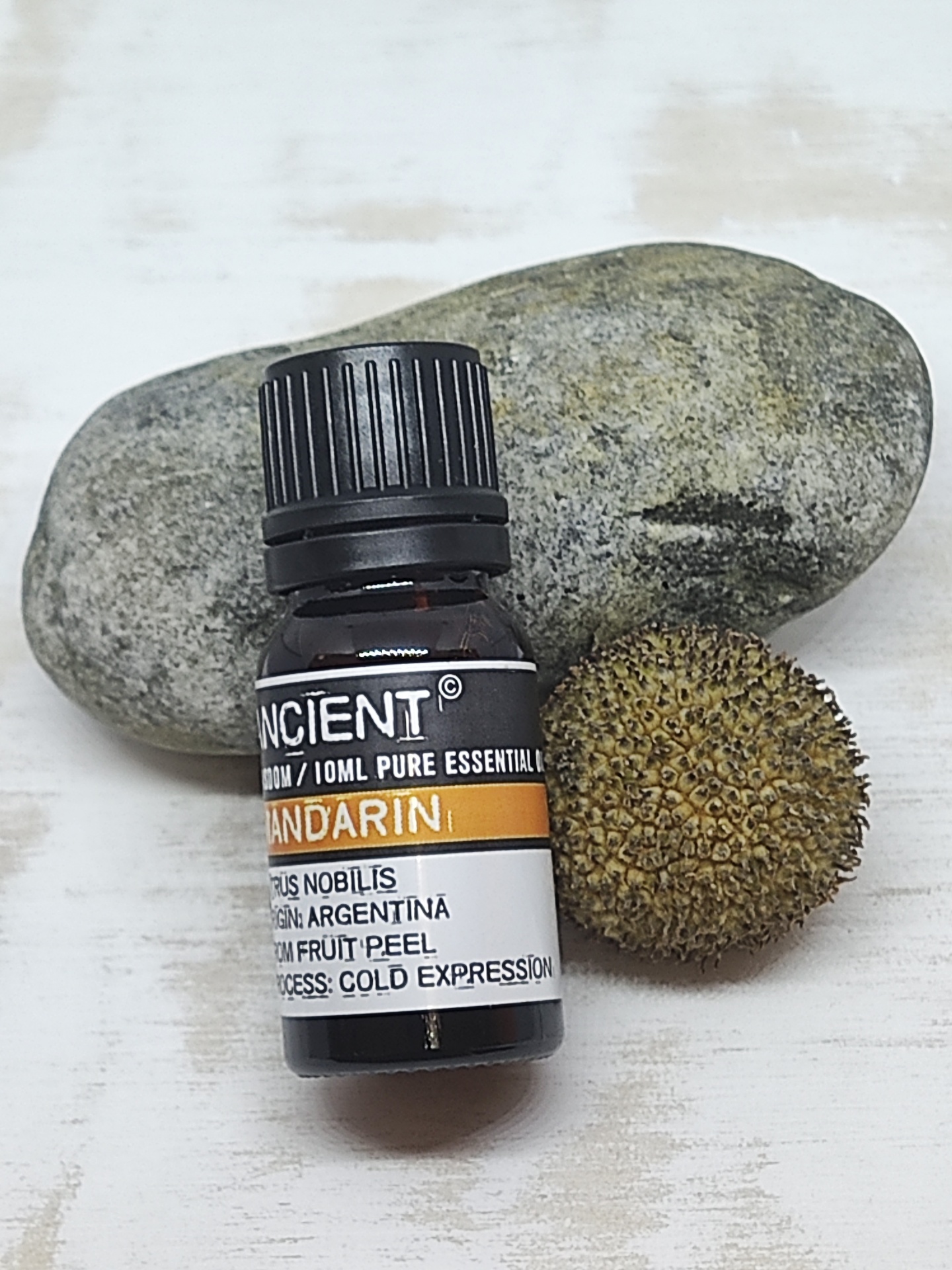 Frasco de óleo essencial de mandarina com pedra e semente