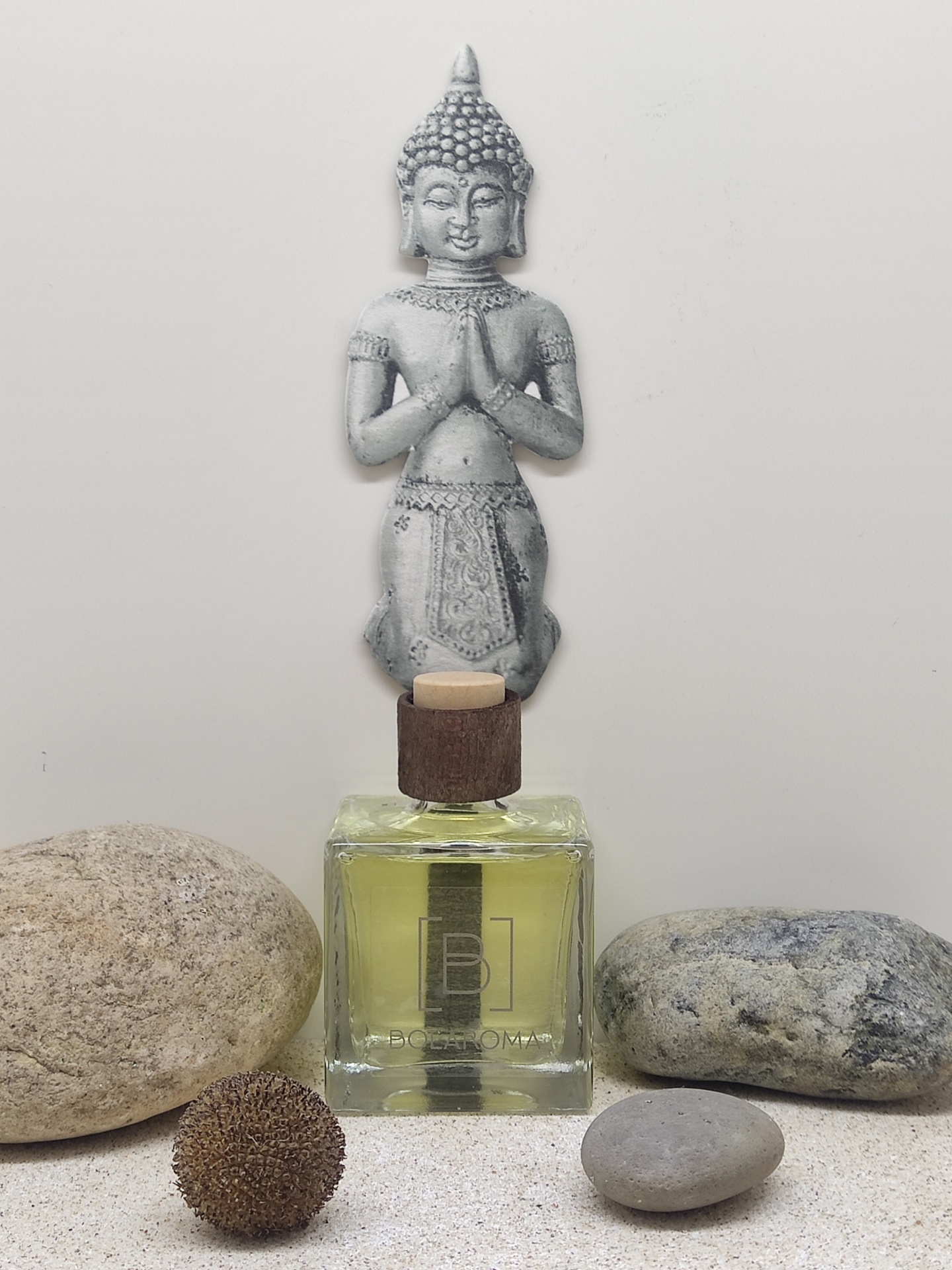 Difusor de aroma com figura de Buda em cima e pedras naturais em volta