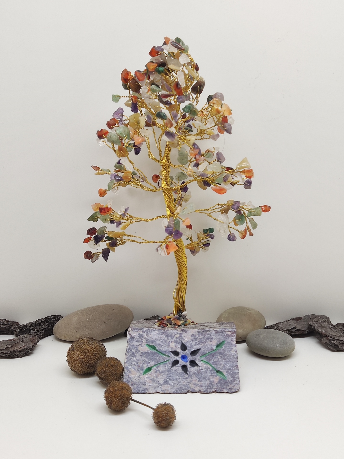 Árvore decorativa com pedras coloridas em base roxa com padrão floral