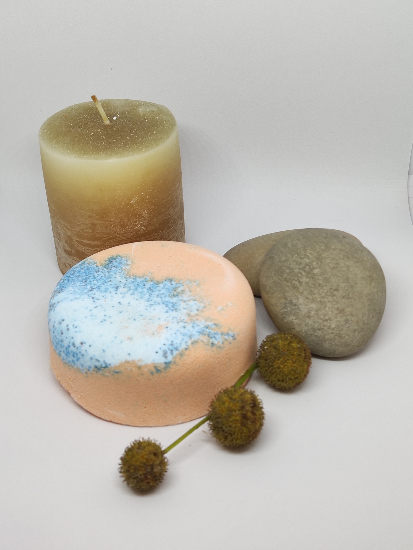 Velas decorativas, pedras cinza e flores secas em estúdio