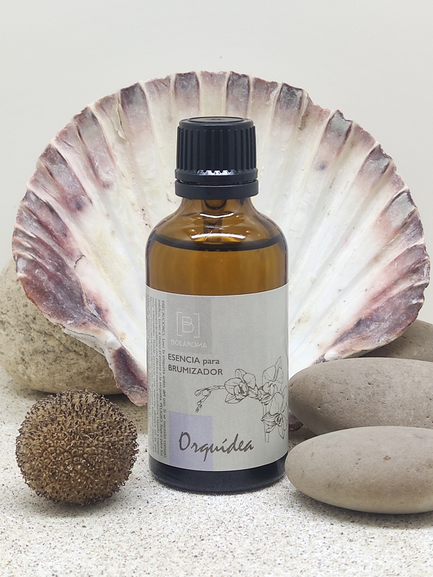 Frasco âmbar com essência para brumizador e elementos naturais ao redor