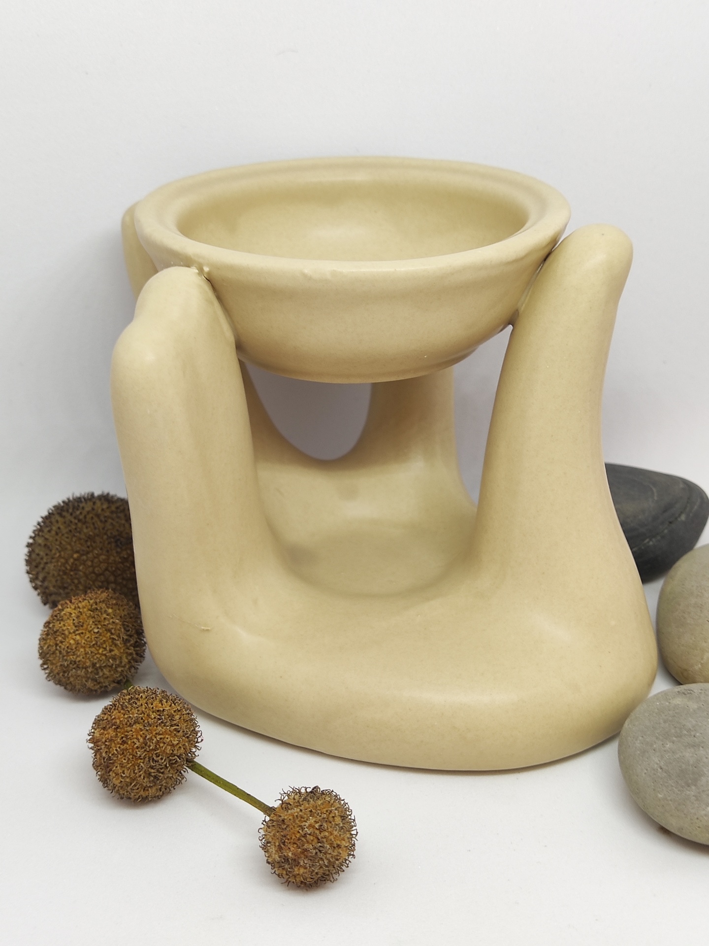 Difusor de cerâmica em forma de mão com pedras e flores secas