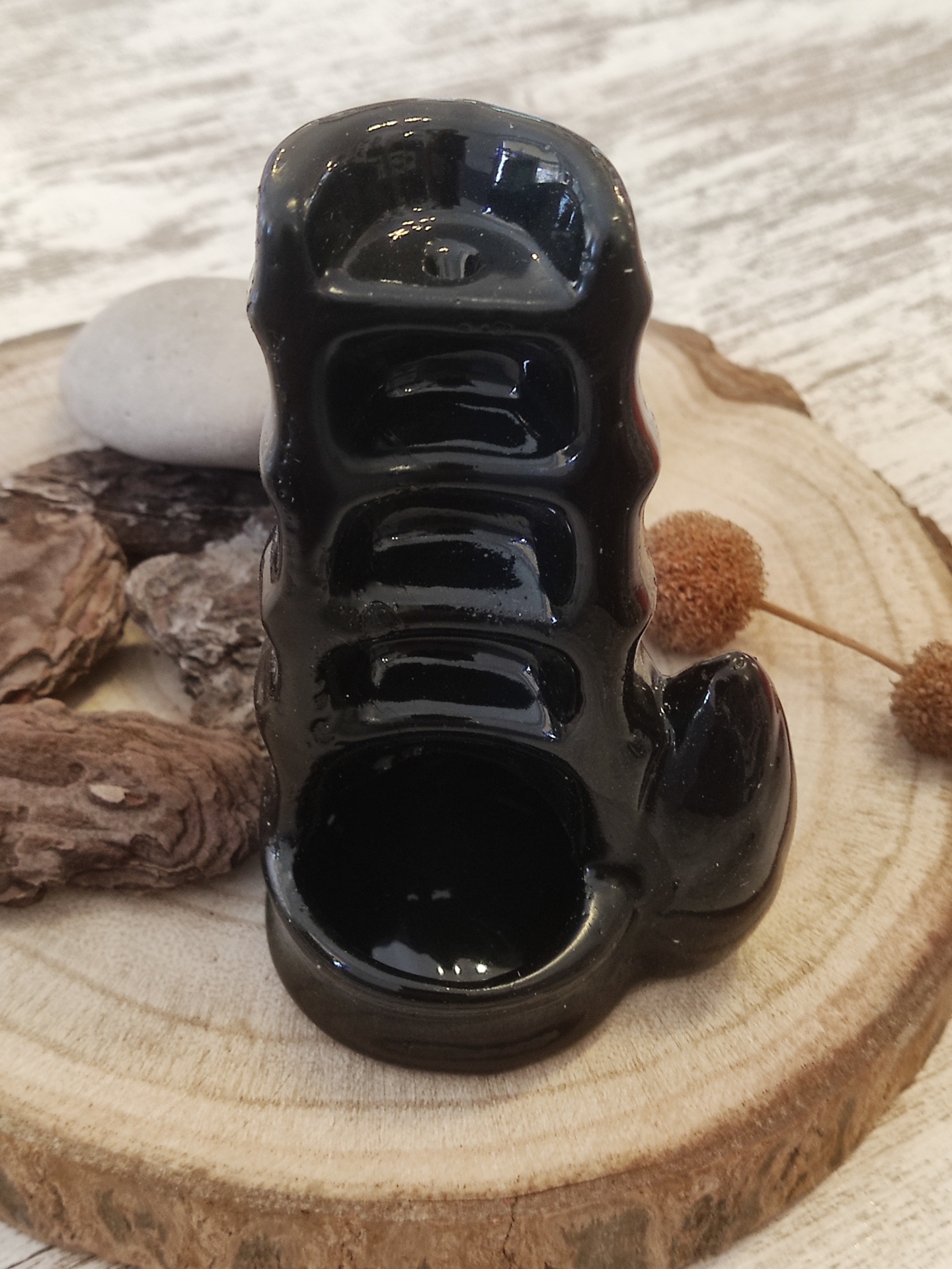 Porta incenso cerâmico preto em base de madeira com troncos e pedras