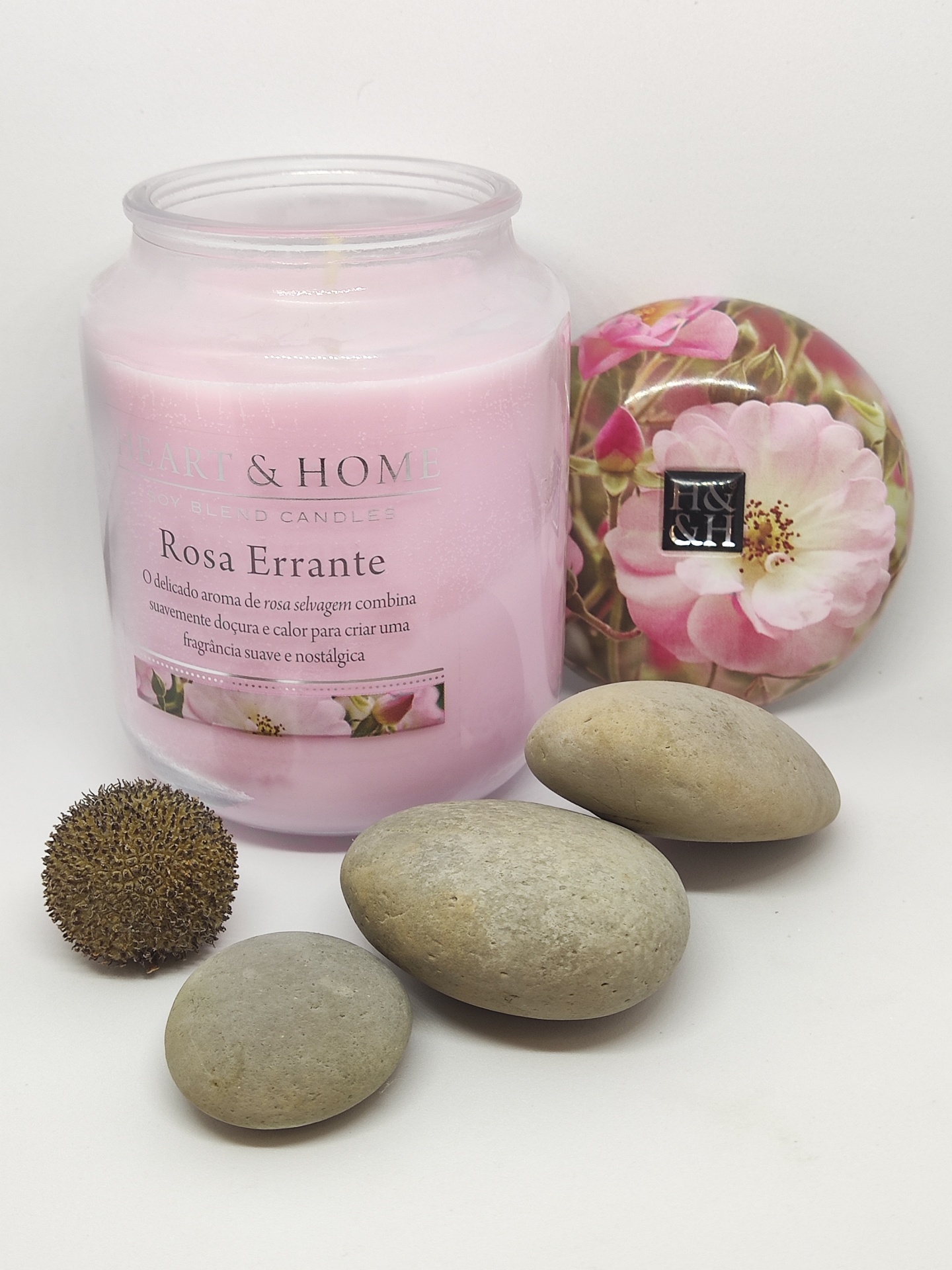 Vela perfumada rosa com tampa floral e pedras cinzentas