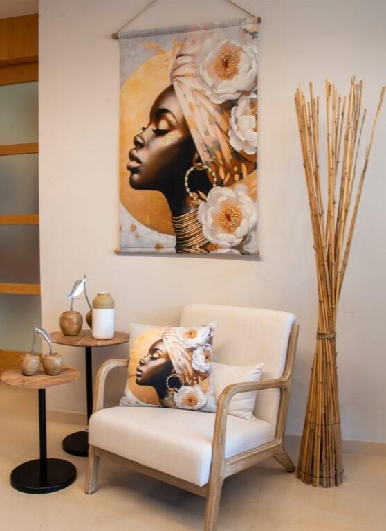 Poltrona creme com almofada estampada, quadro com mesma imagem e decoração em madeira