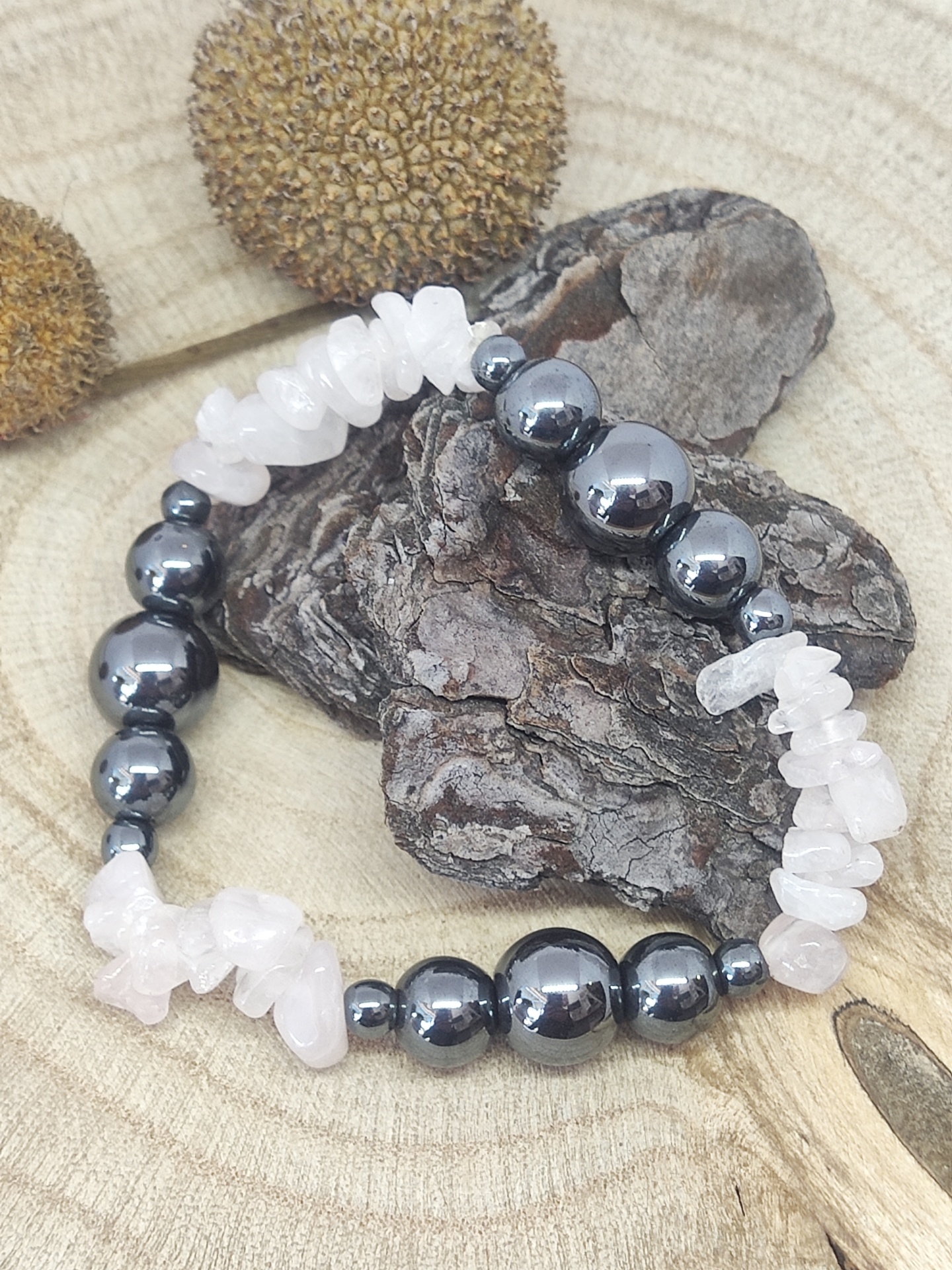 Pulseira de contas pretas e pedras transparentes sobre madeira rústica