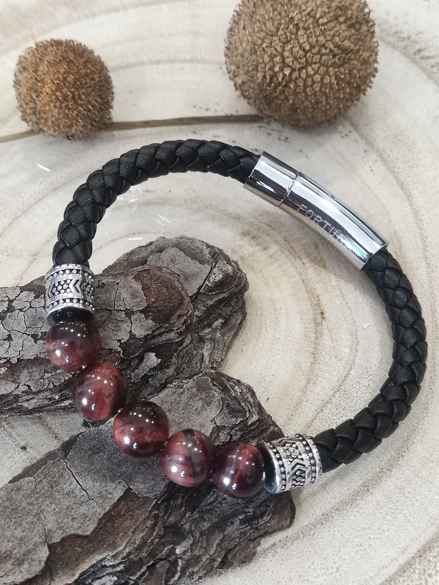 Pulseira preta de couro trançado com contas vermelhas e fecho metálico prateado