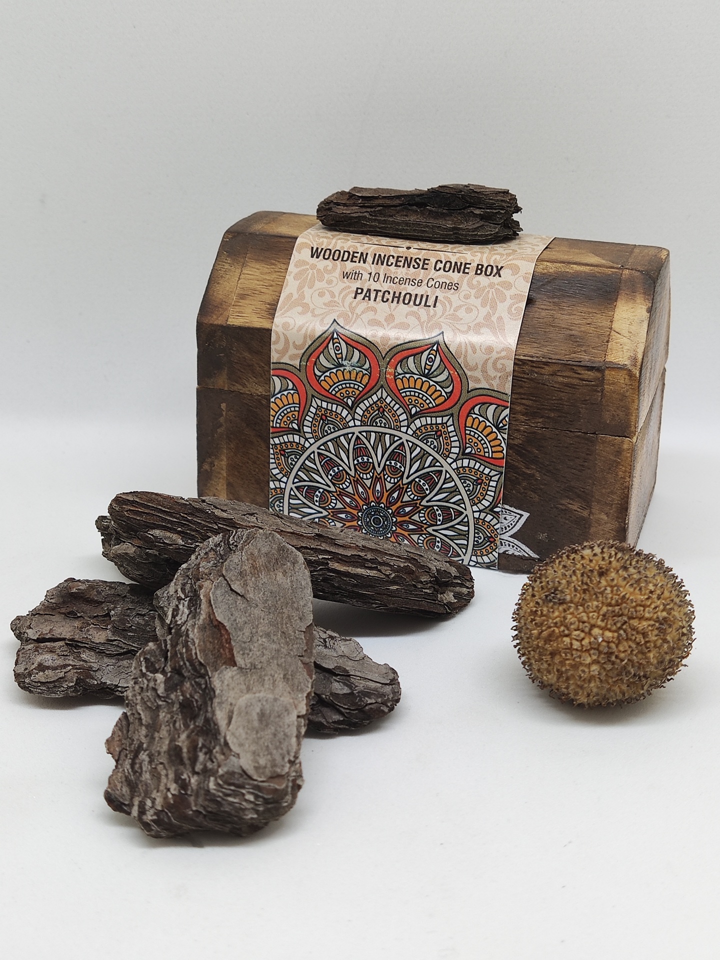 Caixa de madeira para cones de incenso com etiqueta e pedaços de casca de árvore e esfera castanha