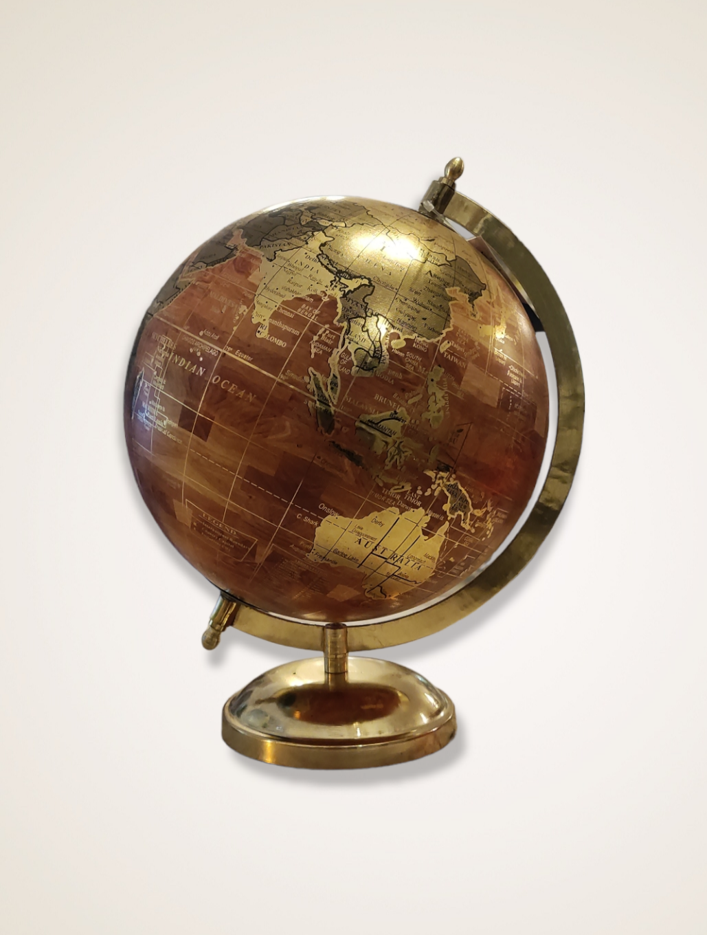 Globo terrestre decorativo dourado e castanho sobre fundo branco