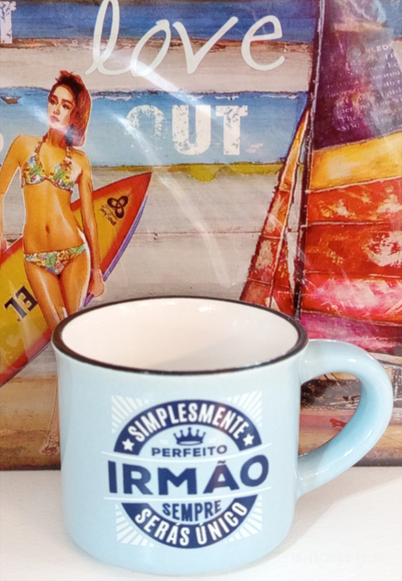 Caneca azul claro com texto azul escuro e imagem de mulher com prancha de surf ao fundo