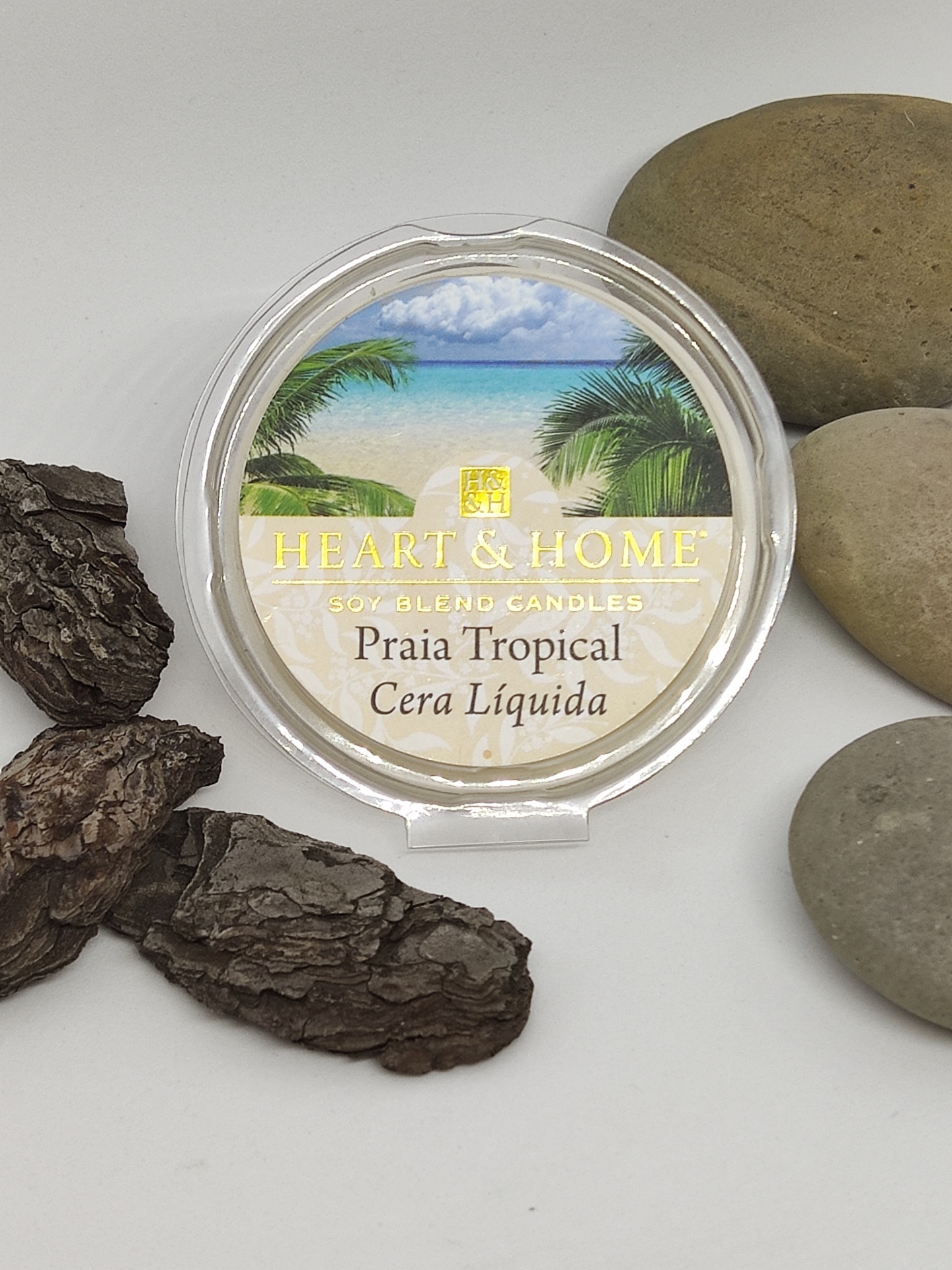 Recipiente de cera líquida HEART & HOME Praia Tropical com decoração natural ao redor.