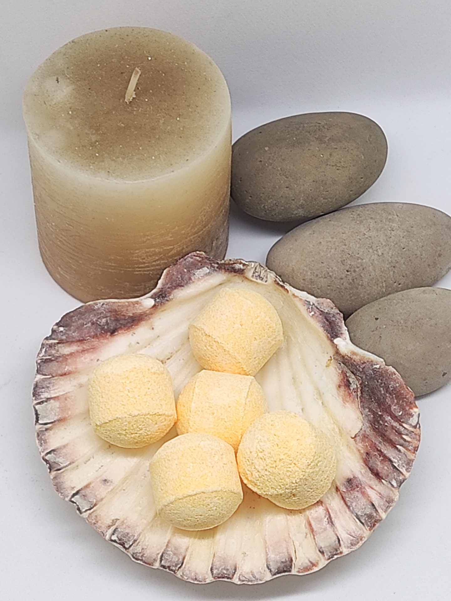 Velão, bolas efervescentes amarelas em concha e pedras ovais cinzentas