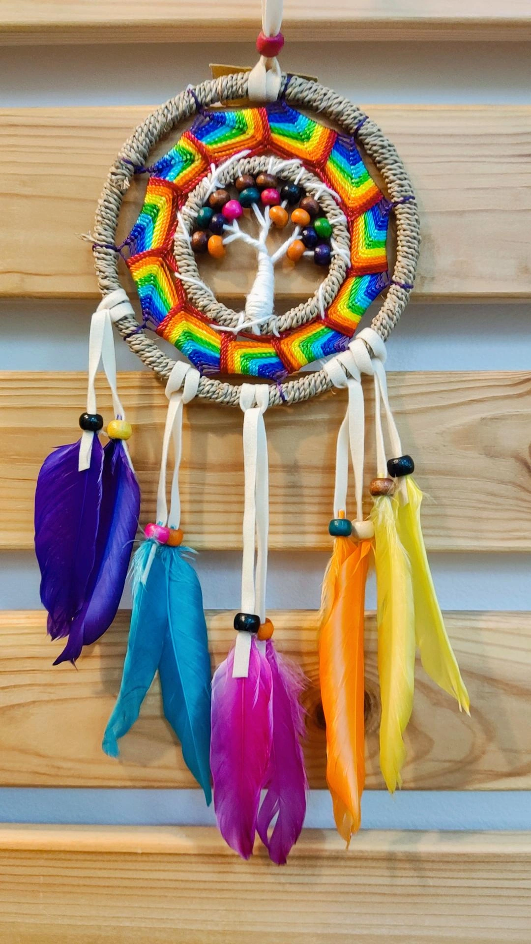Apanhador de sonhos colorido com penas e contas de madeira