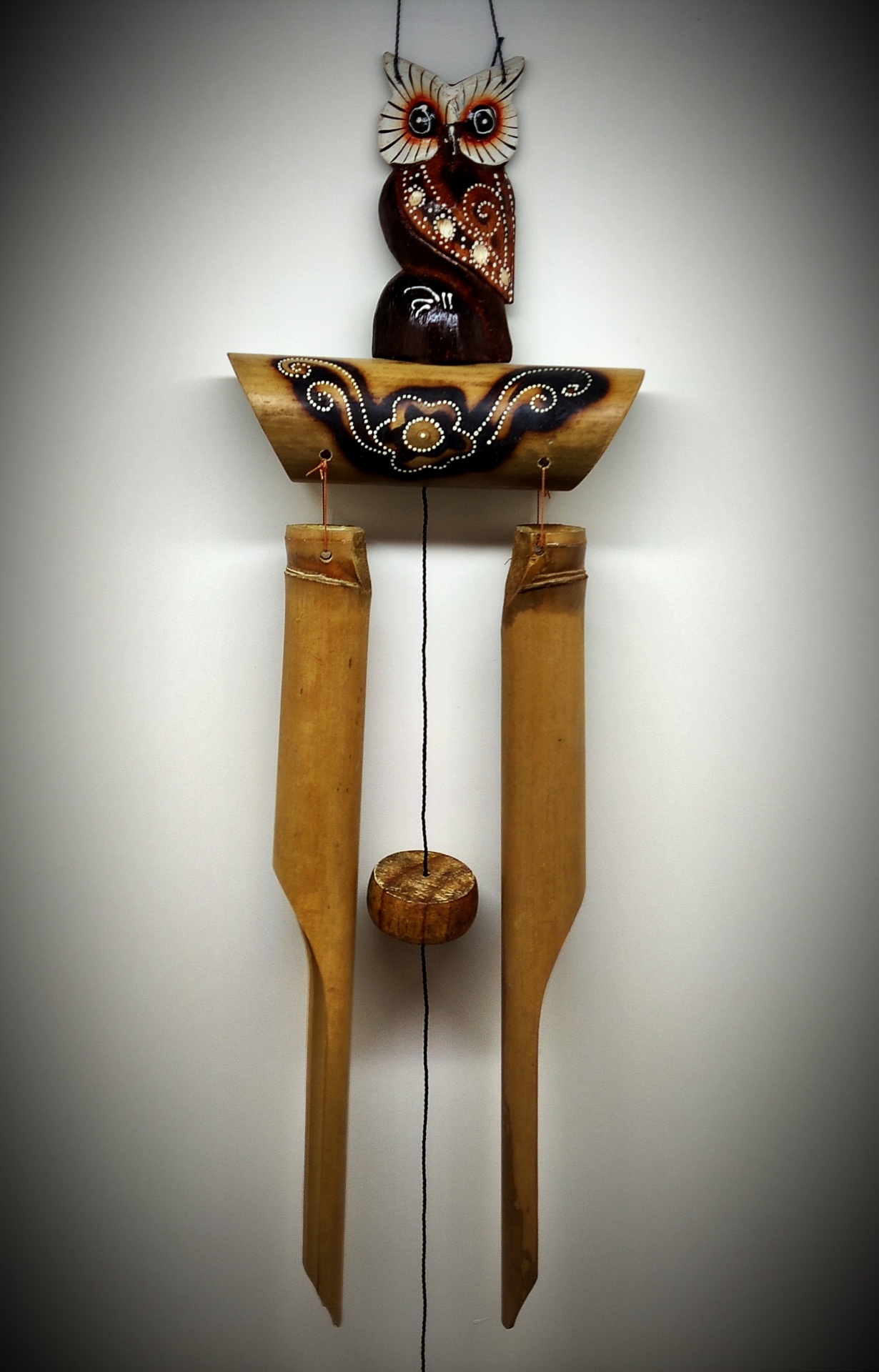 Sino dos ventos em madeira com coruja esculpida e detalhes florais pintados