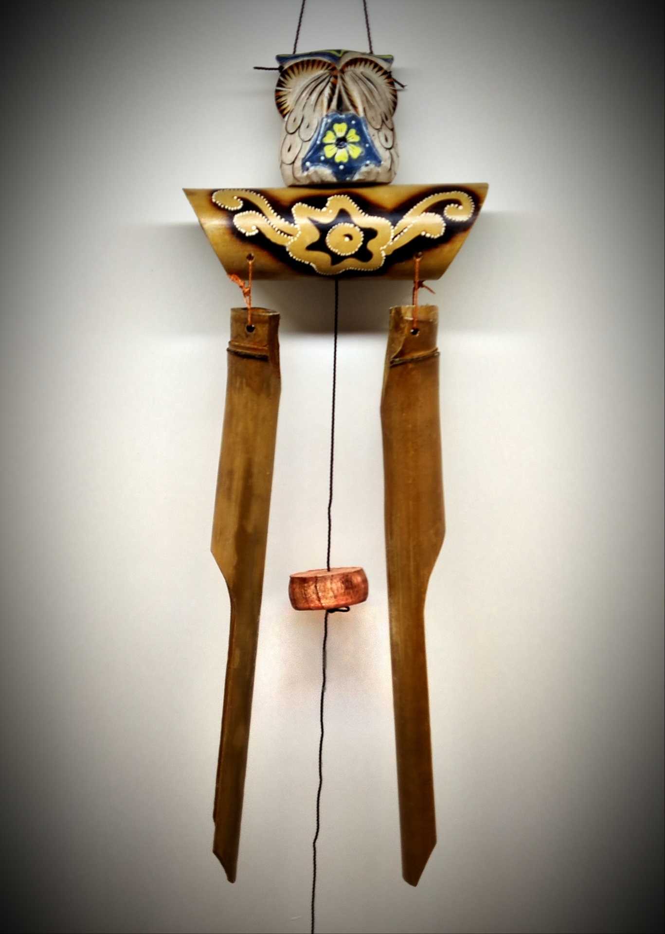 Duelo decorativo em madeira com figura de coruja pintada, pendurado na parede