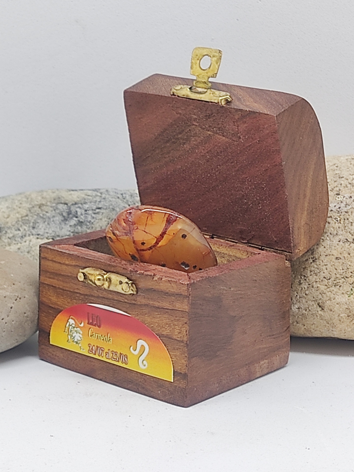 Caixa de madeira aberta com pedra castanha e etiqueta do signo Leão