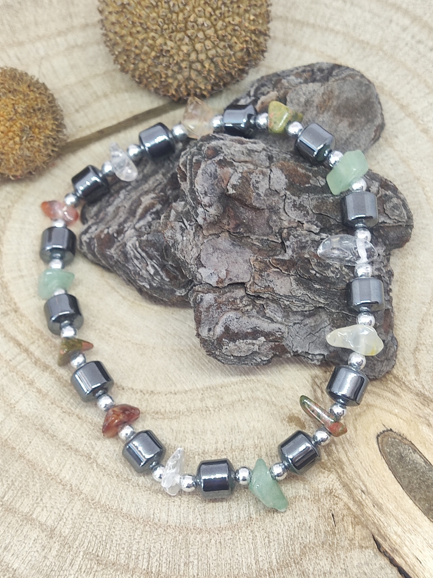 Pulseira com pedras naturais e contas metálicas sobre madeira