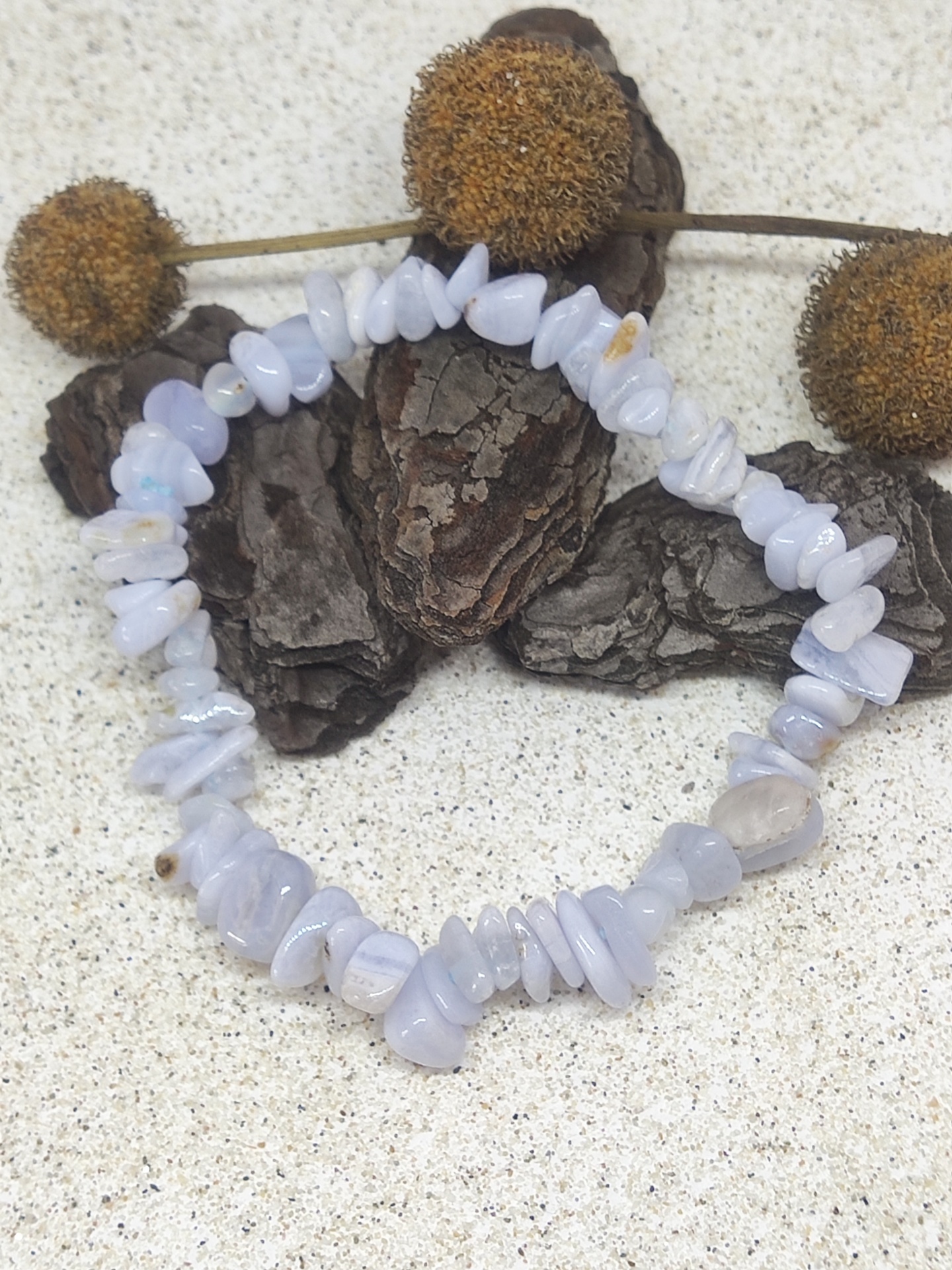 Pulseira de pedras azuis claras com moldura de cascas de pinheiro e flores secas castanhas