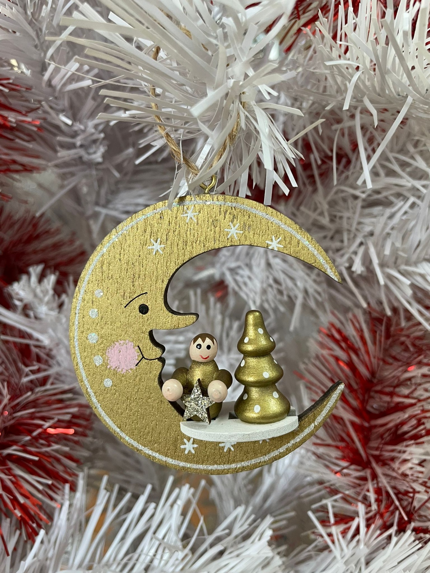 Enfeite de Natal lua dourada com anjo e árvore em madeira pendurado em árvore branca com pontas vermelhas