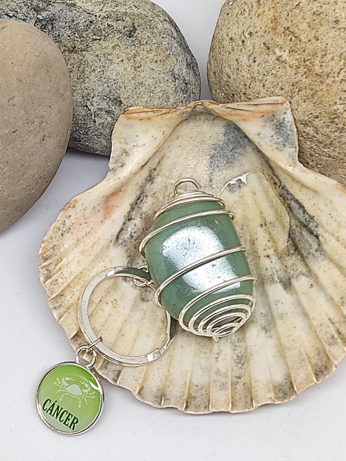 Chaveiro com pedra verde e medalhão CANCER sobre concha e pedras