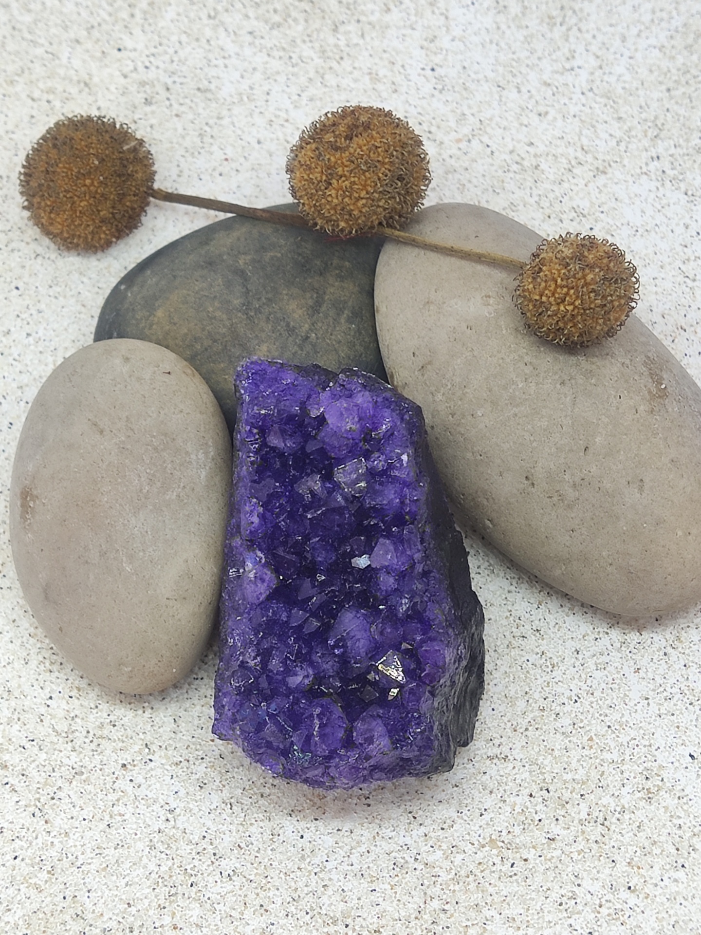 Cristal roxo de ametista com pedras lisas e ramos secos castanhos