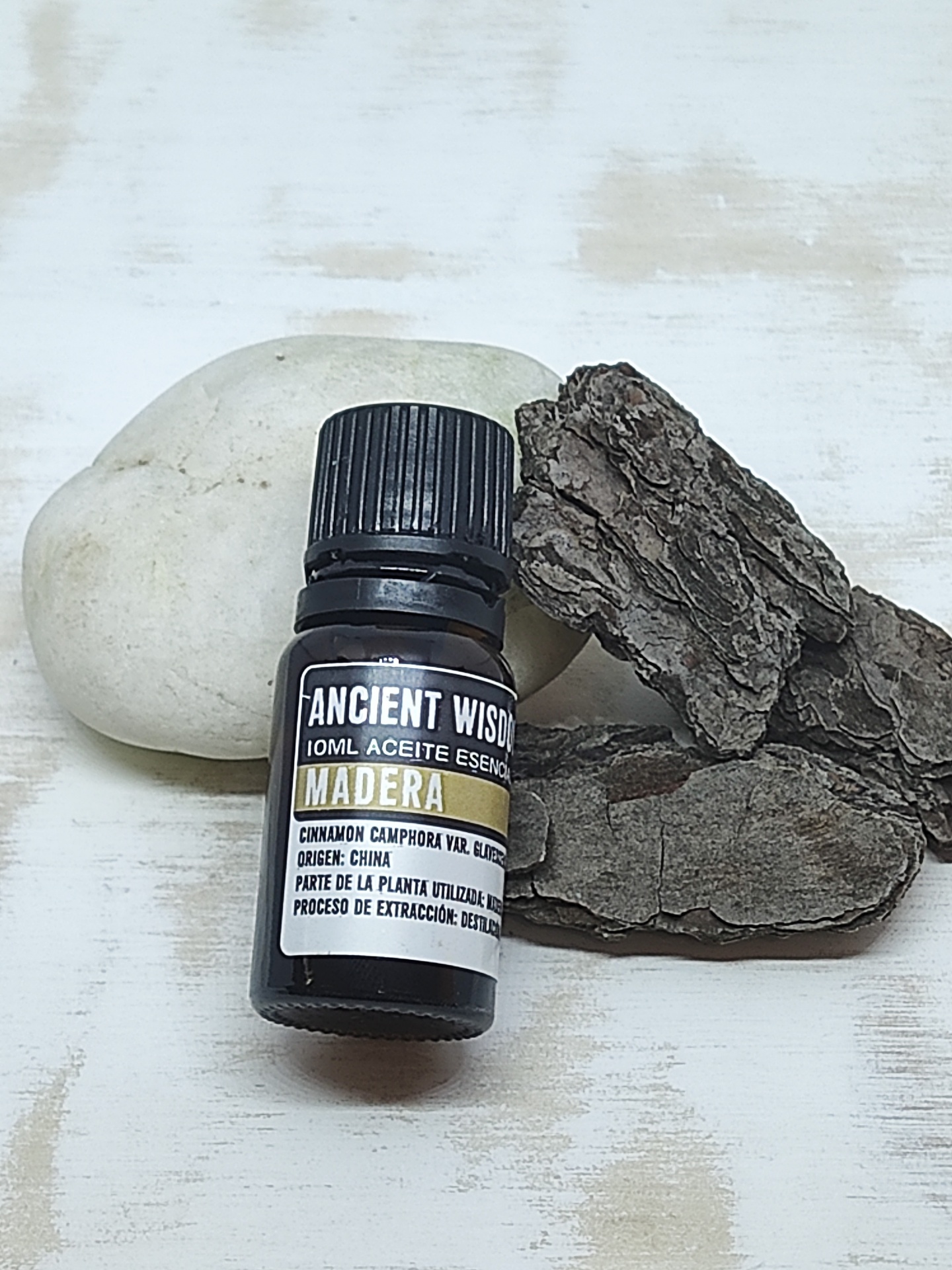 Frasco de óleo essencial em vidro escuro com pedra e casca de árvore