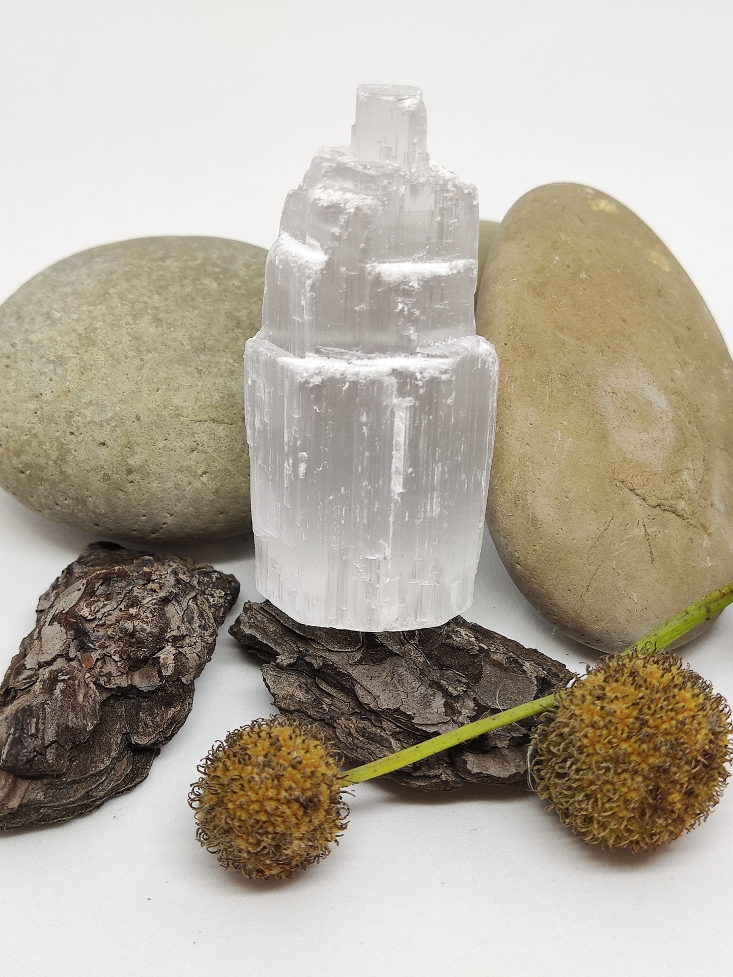 Cristal branco translúcido com pedras e elementos naturais em fundo branco