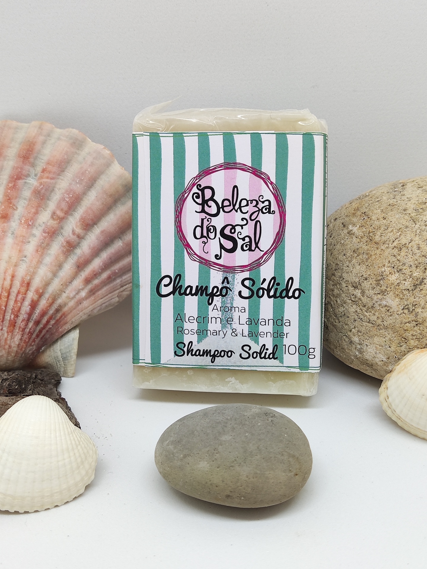 Champo sólido Beleza do Sal com embalagem às riscas verdes e brancas entre conchas e pedras